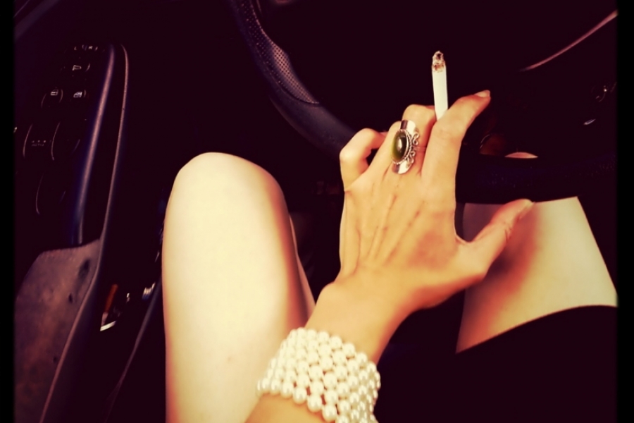 Femeie fumând în mașină