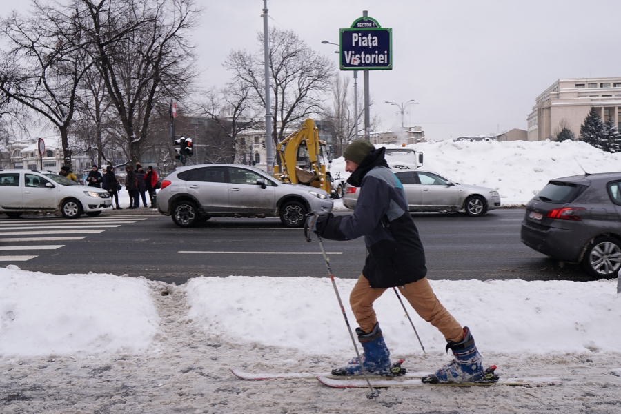 zapada - barbat cu schiuri in Piata Victoriei
