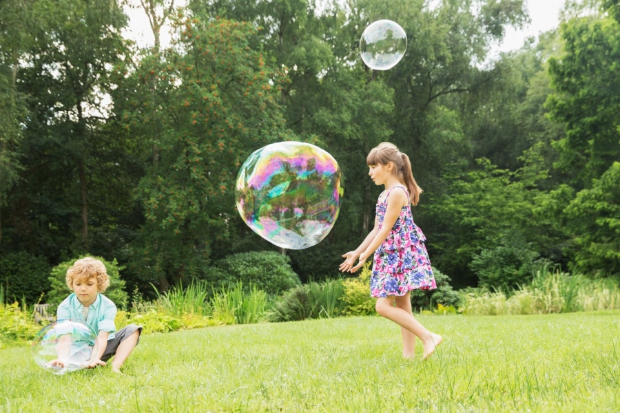 Copii jucându-se cu baloane de săpun