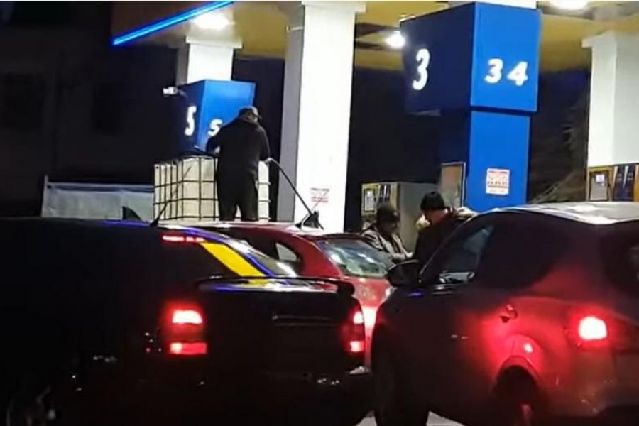 Roman filmat în timp ce umple cu benzină un container