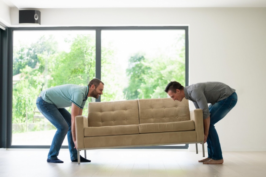 Bărbați mutând o canapea